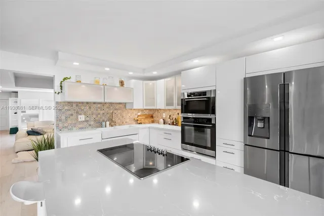 a kitchen with a sink stainless steel appliances and white cabinets