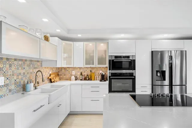 a kitchen with granite countertop a refrigerator stove and sink