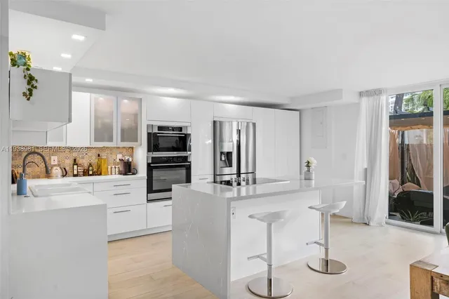 a kitchen with stainless steel appliances kitchen island granite countertop a sink and cabinets