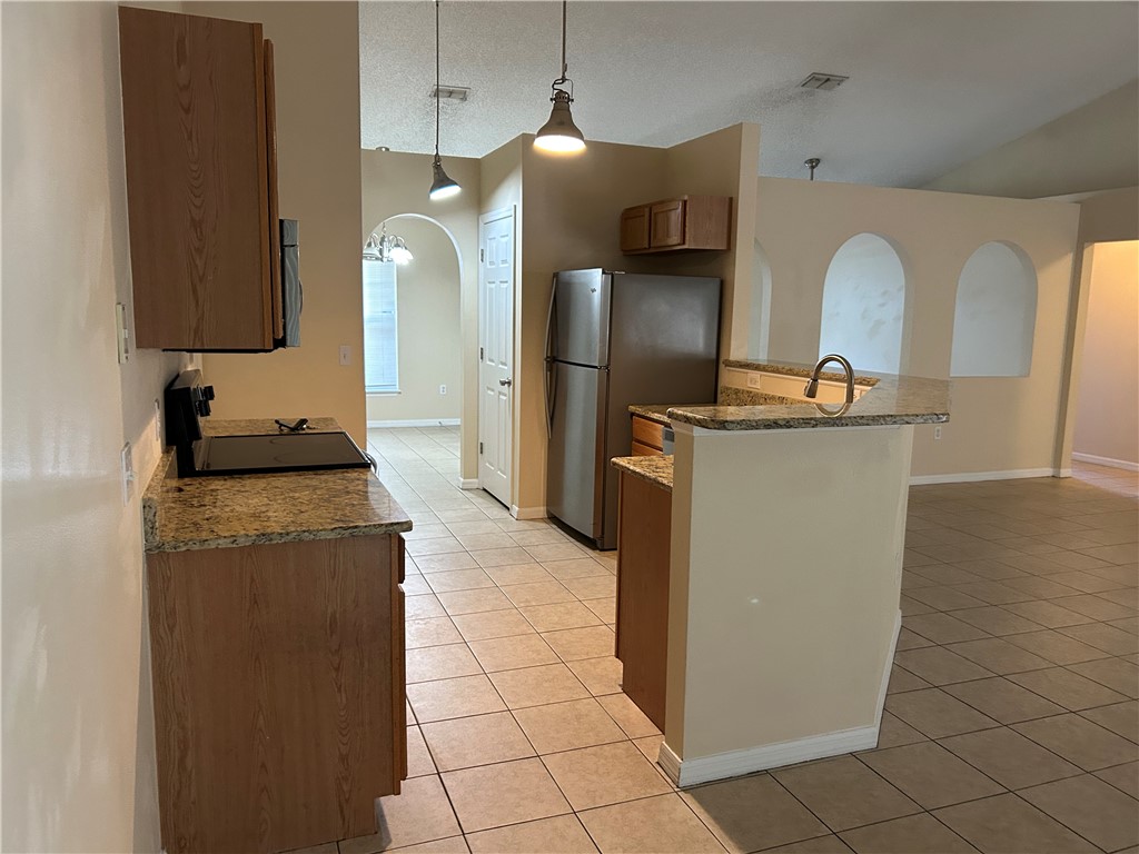675 Forster Avenue Sebastian, FL 32958 - Photo 7 of 15 a kitchen with stainless steel appliances granite countertop a sink a stove and a refrigerator