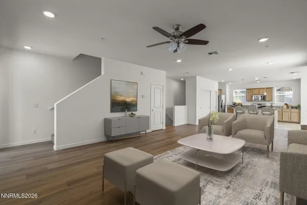 a living room with furniture and a view of kitchen