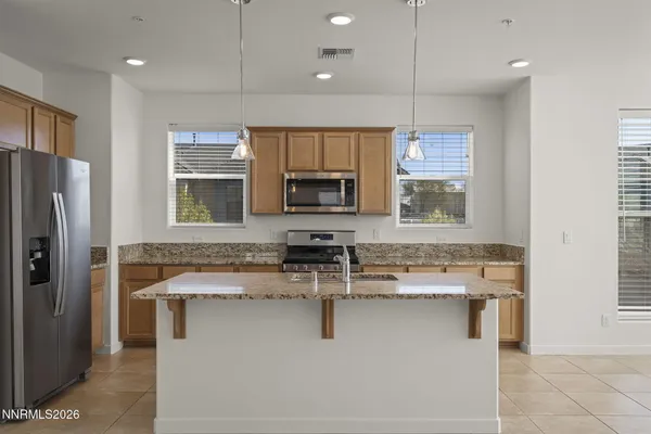 a kitchen with kitchen island granite countertop a sink appliances and cabinets