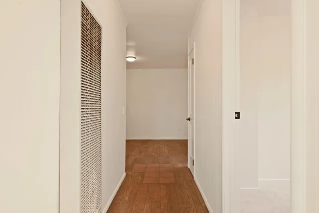 a view of a hallway with wooden floor