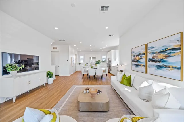 a kitchen with a sink a stove a refrigerator and white cabinets with wooden floor