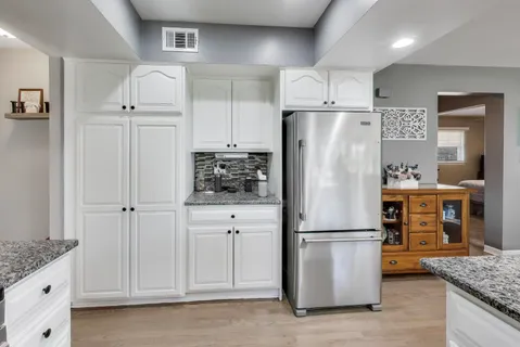 a kitchen with stainless steel appliances granite countertop a stove top oven a refrigerator a sink and a refrigerator