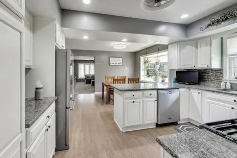 a kitchen with stainless steel appliances granite countertop a stove a sink and a microwave