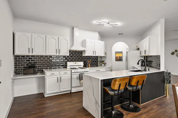 a kitchen with stainless steel appliances granite countertop a sink stove and cabinets