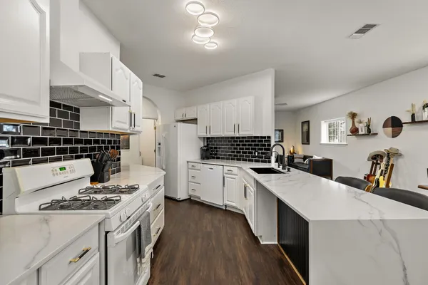 a kitchen with a stove a sink dishwasher and a refrigerator