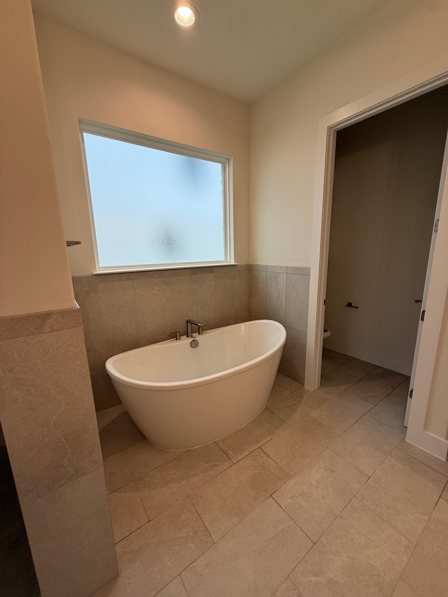 110 Firestone Place Meadowlakes, TX 78654 - Photo 11 of 18 Freestanding soaking tub with chrome fixtures, set against a tiled half-wall