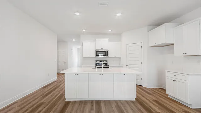 a kitchen with white cabinets and stainless steel appliances