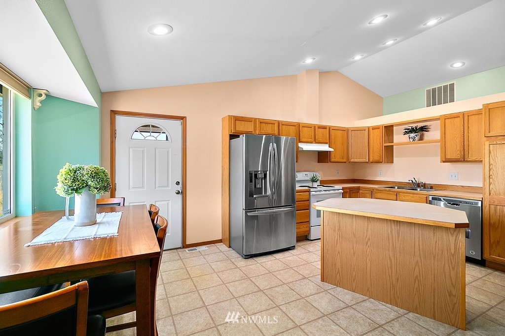 5121 183rd Lane Southwest Rochester, WA 98579 - Photo 18 of 31 a kitchen with stainless steel appliances a refrigerator a stove a sink and a dining table