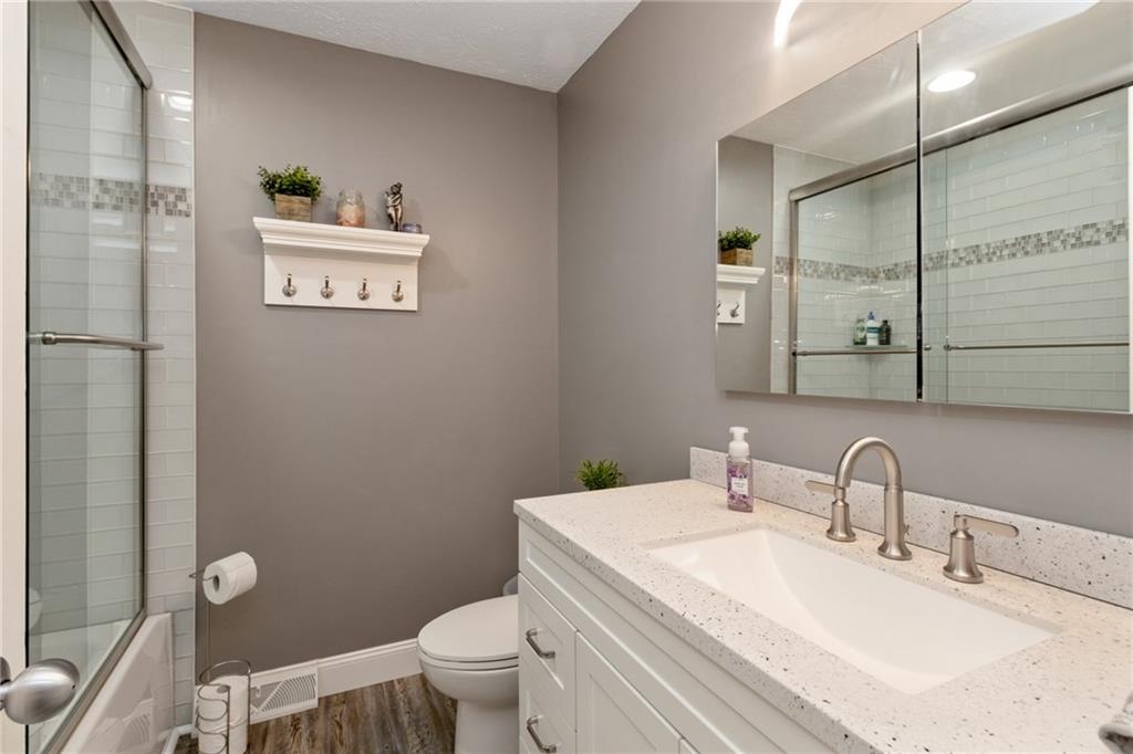 174 Cedar Ridge Drive Monaca, PA 15061 - Photo 17 of 22 Completely updated in 2018 this full bath features vinyl planked flooring, glass subway tile with mosaic glass accents & stone topped vanity.