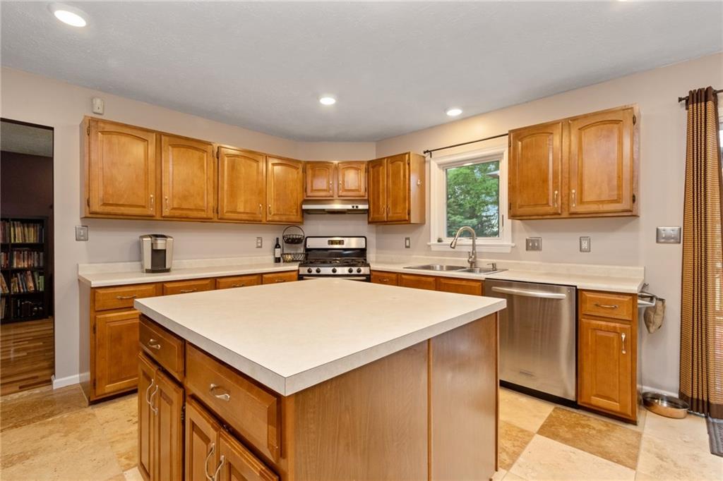 174 Cedar Ridge Drive Monaca, PA 15061 - Photo 4 of 22 Natural stone Travertine flooring & tons of wood cabinets lend warmth to the kitchen while recessed lighting & SS appliances give the space bright modern infusion.