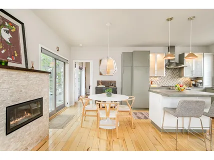 a view of a dining room with furniture a fireplace and wooden floor