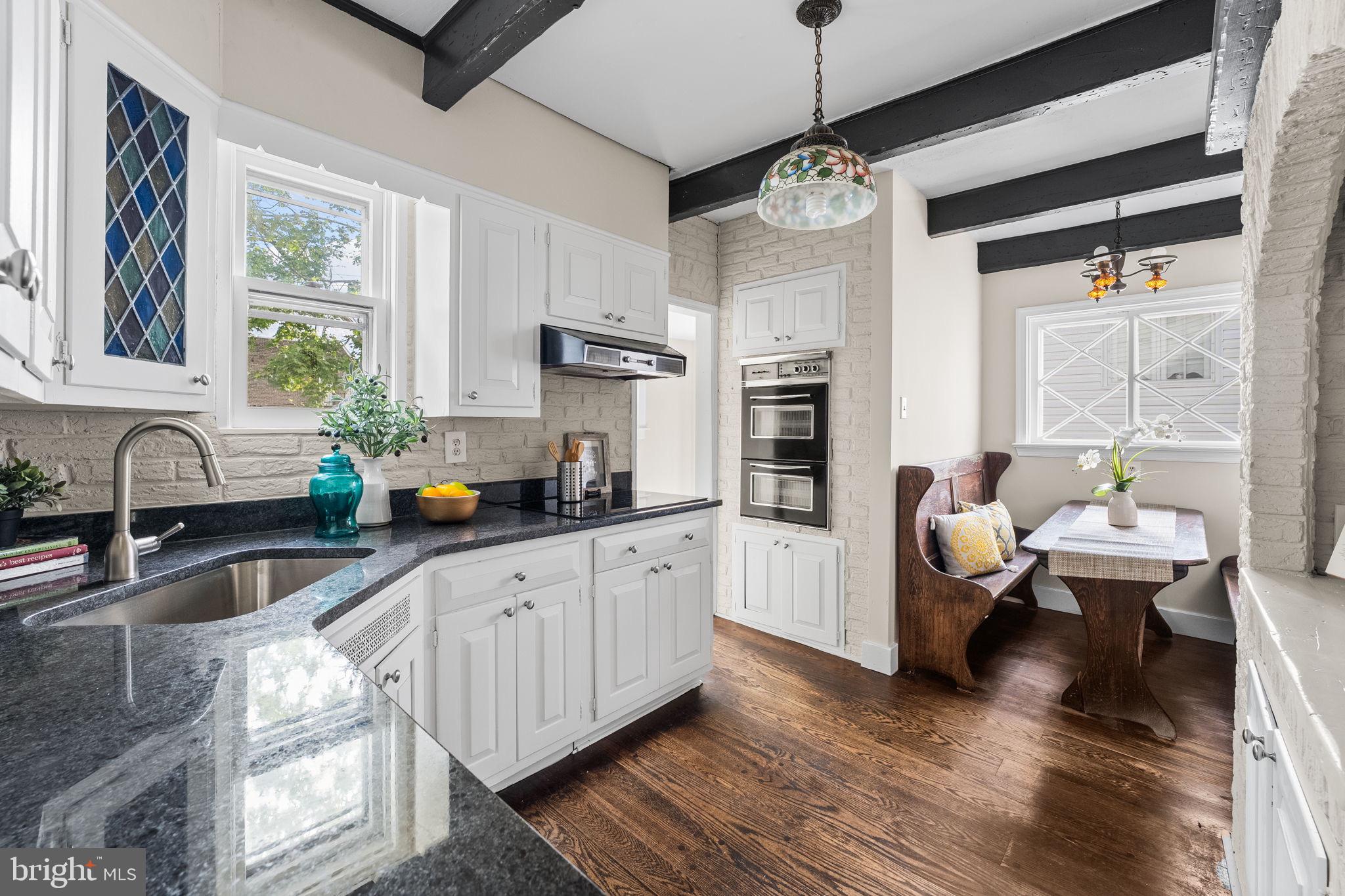 96 Drexel Avenue Lansdowne, PA 19050 - Photo 12 of 58 a large white kitchen with stainless steel appliances granite countertop a stove a sink dishwasher and white cabinets with wooden floor