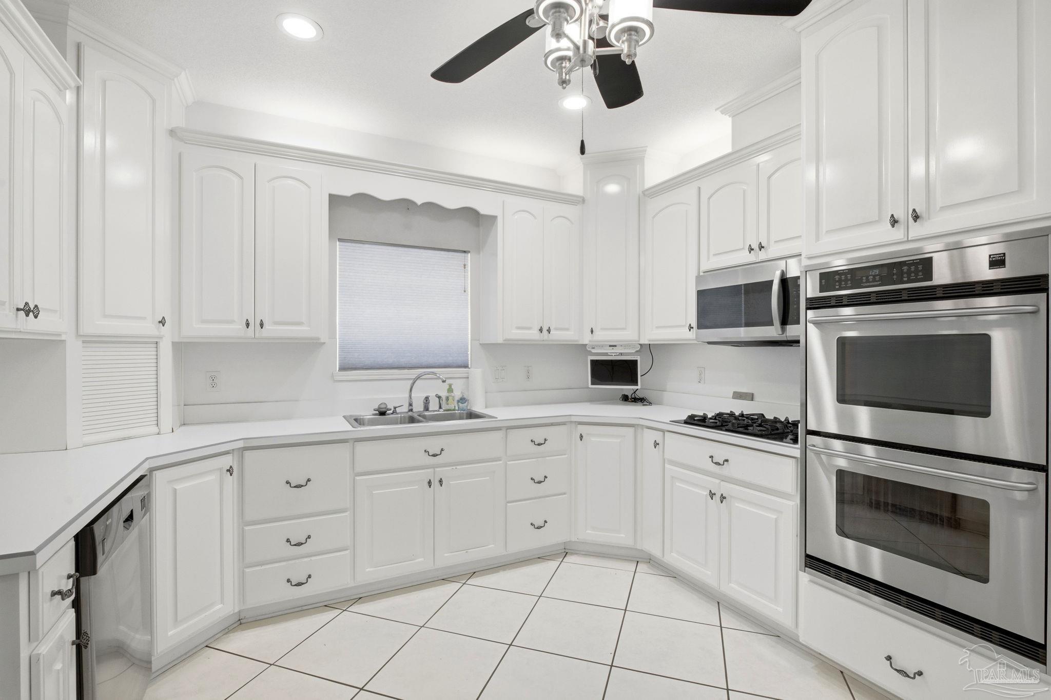 4552 Peaden Road Pace, FL 32571 - Photo 21 of 38 a kitchen with white cabinets and appliances