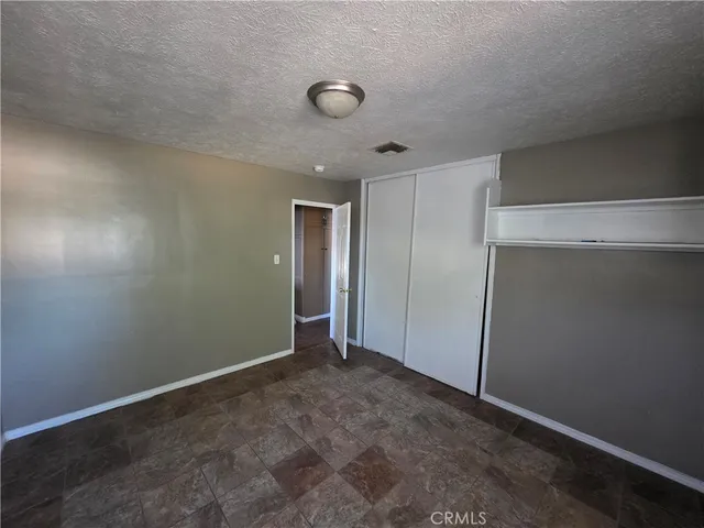 an empty room with closet and a window