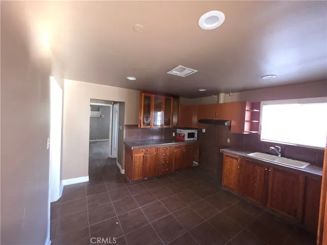 a large kitchen with a large counter top and stainless steel appliances