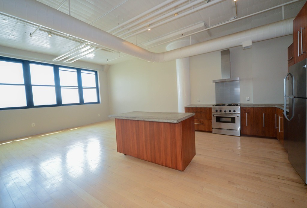 437 D Street, Unit 2C Boston, MA 02210 - Photo 2 of 13 a kitchen with stainless steel appliances granite countertop a stove a sink and a refrigerator