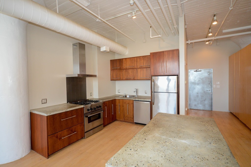 437 D Street, Unit 2C Boston, MA 02210 - Photo 3 of 13 a kitchen with a refrigerator sink and wooden cabinets