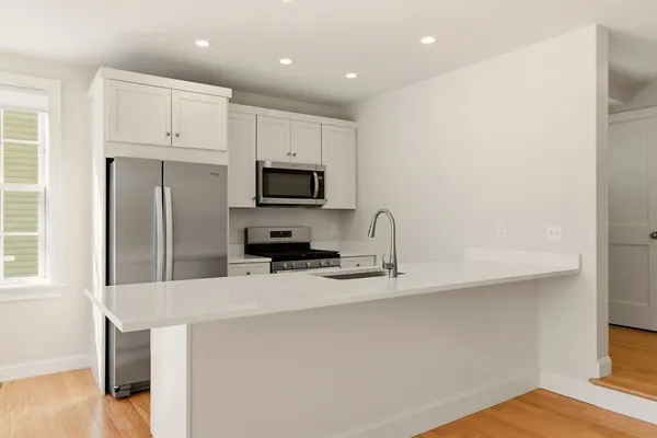 a kitchen with white cabinets a sink and stainless steel appliances