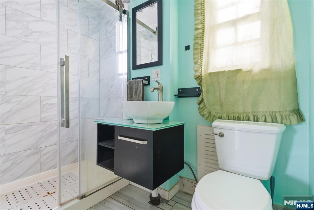 327 Field Place Hillside, NJ 07205 - Photo 8 of 18 a bathroom with a granite countertop toilet sink and mirror