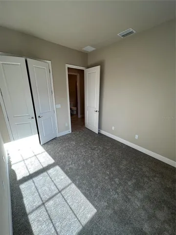 a view of an empty room and a bathroom