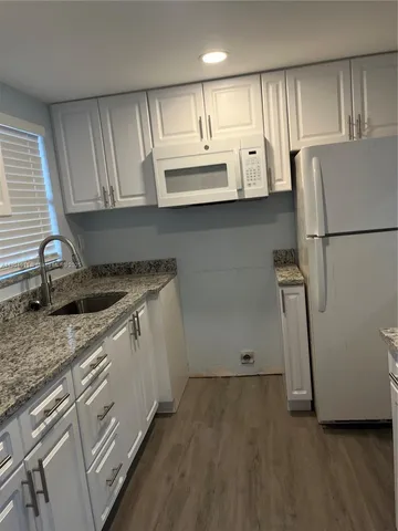 a kitchen with a sink a refrigerator and cabinets