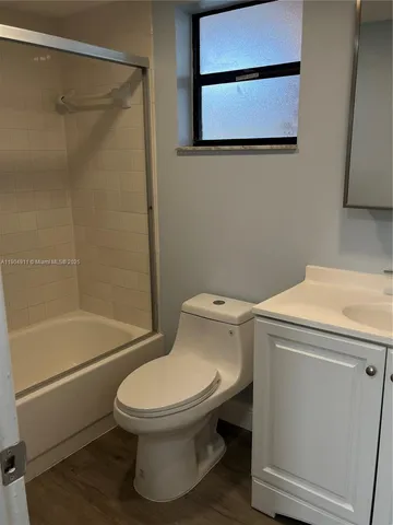 a white toilet sitting next to a bath tub and a shower