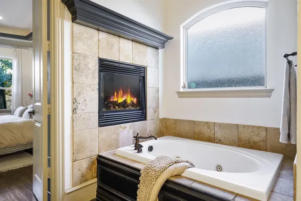 a bathroom with a tub and a view of bathroom