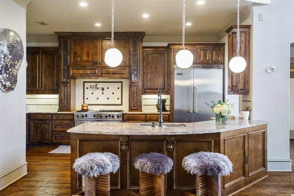 a kitchen with stainless steel appliances granite countertop a stove a sink and a wooden floors