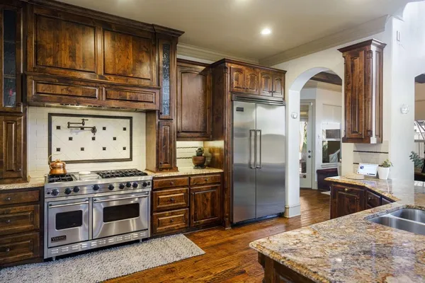 a kitchen with stainless steel appliances granite countertop a stove a refrigerator and a sink