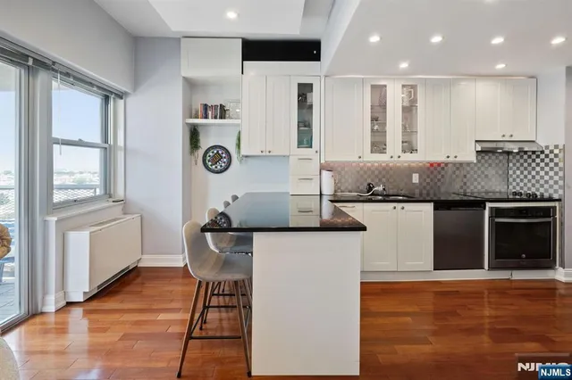 a kitchen with kitchen island granite countertop wooden cabinets and a refrigerator