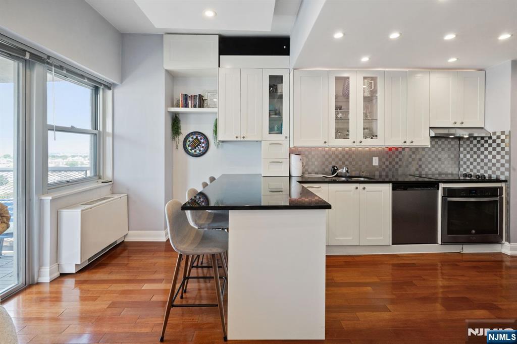a kitchen with kitchen island granite countertop wooden cabinets and a refrigerator