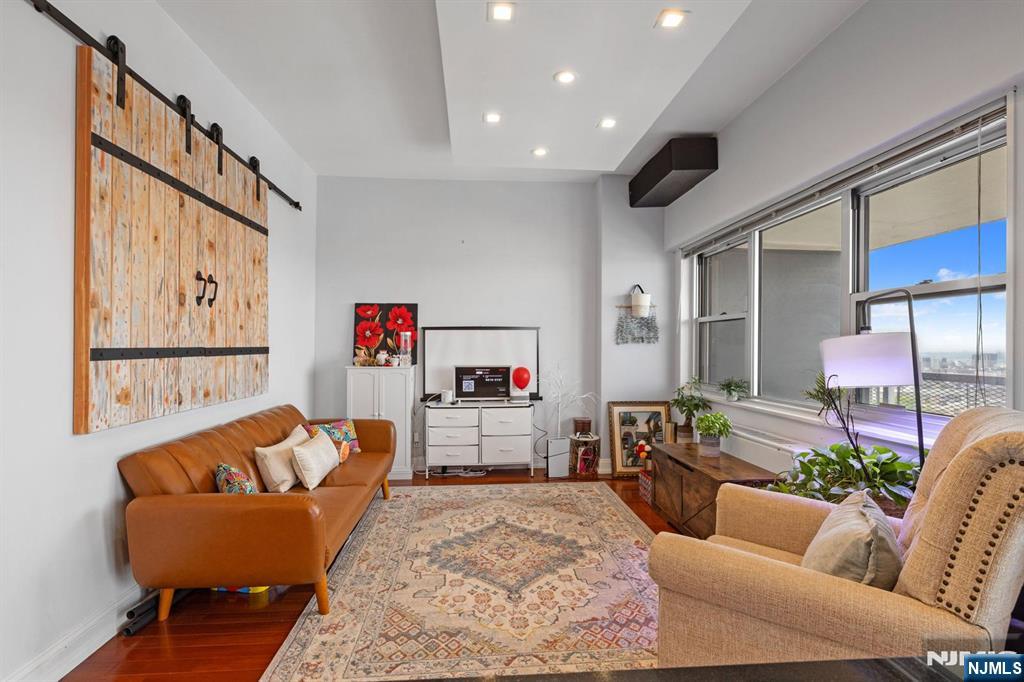 6600 JFK Boulevard East, Unit 23J West New York, NJ 07093 - Photo 6 of 26 a living room with furniture and a flat screen tv
