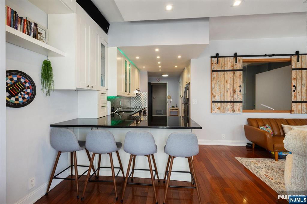 6600 JFK Boulevard East, Unit 23J West New York, NJ 07093 - Photo 8 of 26 a living room with furniture and a wooden floor
