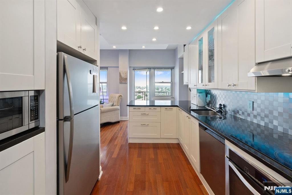 6600 JFK Boulevard East, Unit 23J West New York, NJ 07093 - Photo 10 of 26 a kitchen with a refrigerator a sink and cabinets