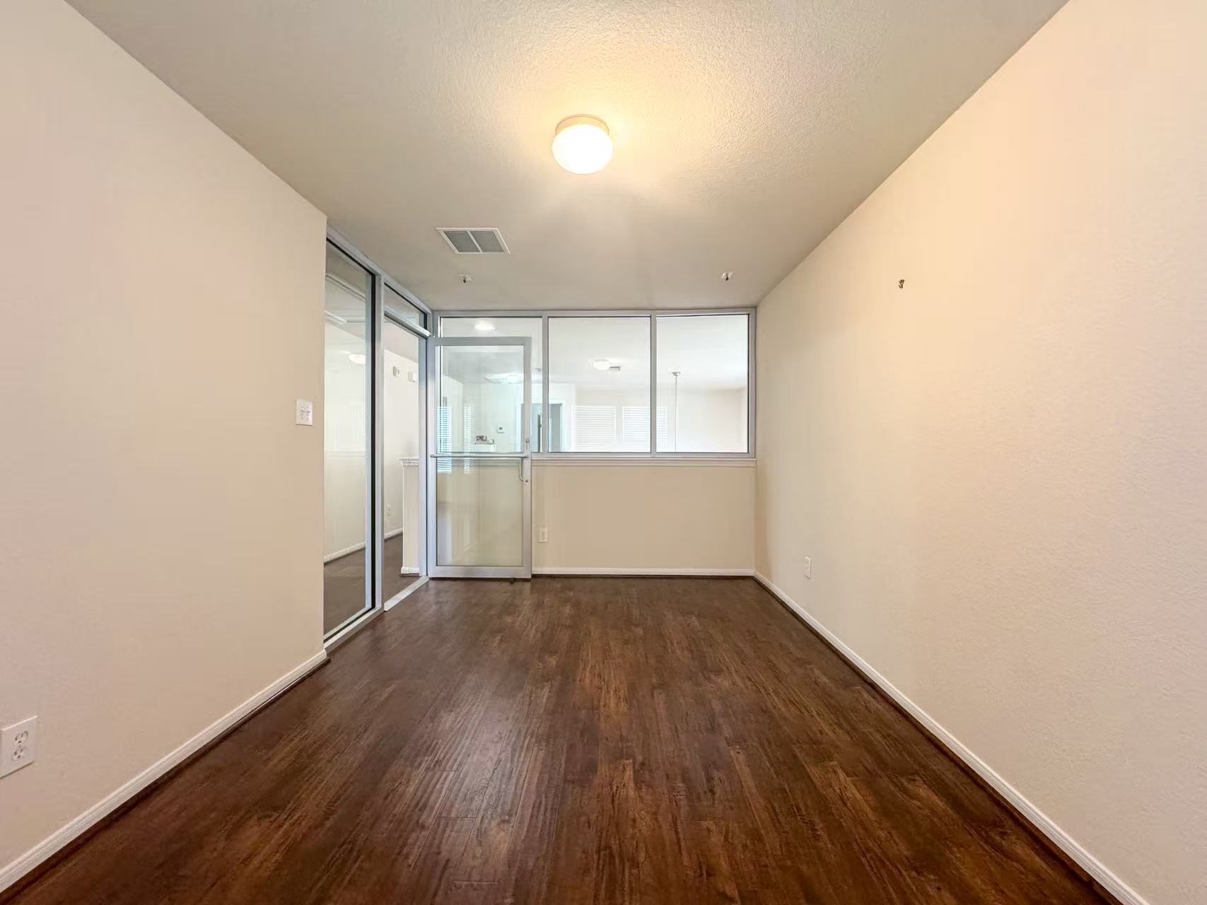 3923 Calgary Circle Missouri City, TX 77459 - Photo 19 of 25 an empty room with wooden floor and windows