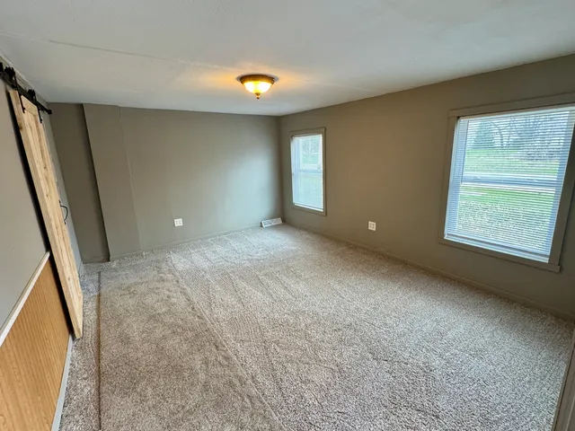 an empty room with windows and entrance