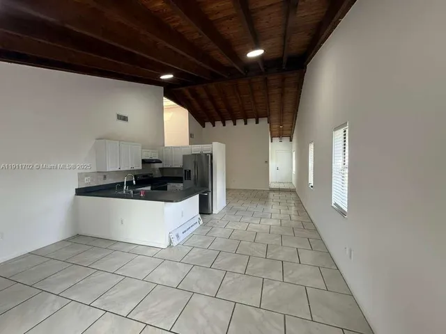 a large white kitchen with a stove a sink and a refrigerator