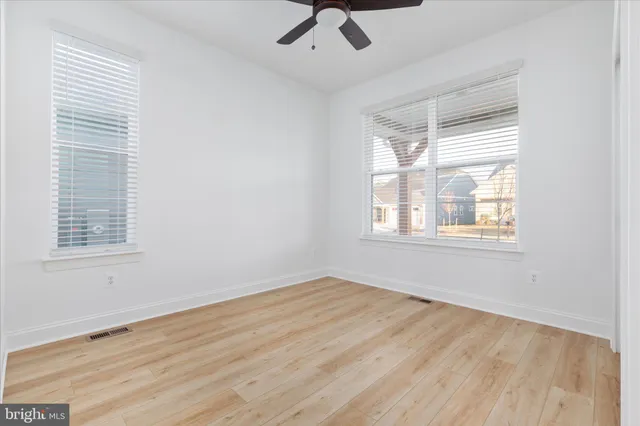 a view of a room with wooden floor and a hallway