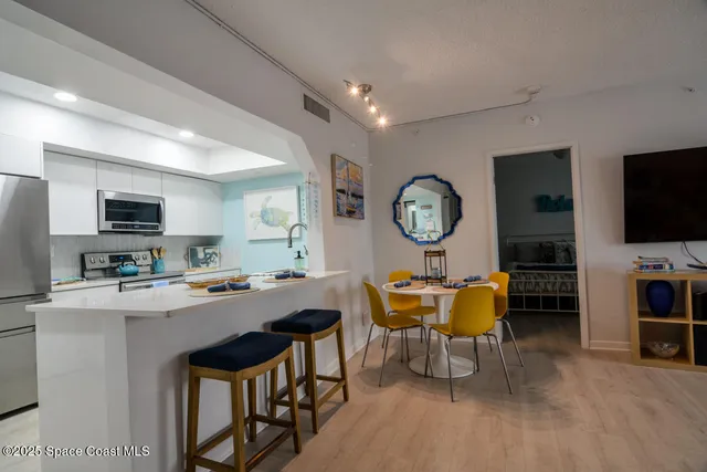 a view of a dining room with furniture and a kitchen
