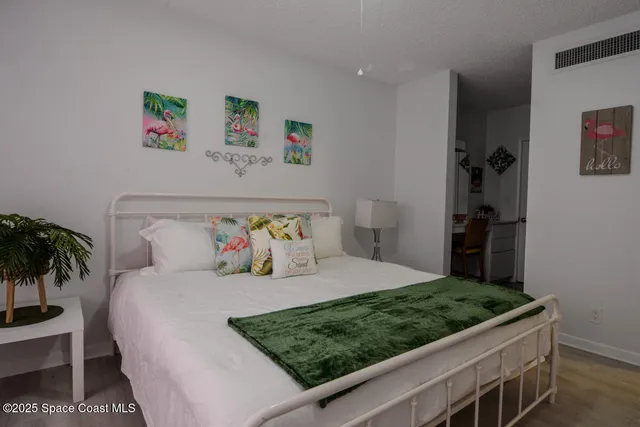 a bedroom with a large bed and a potted plant