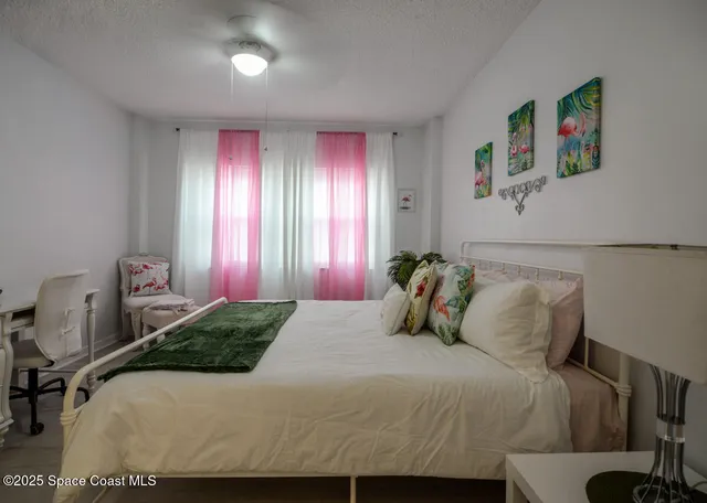 a bedroom with a bed and glass windows