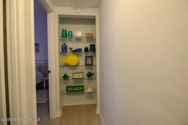 a view of a hallway with wooden shelves