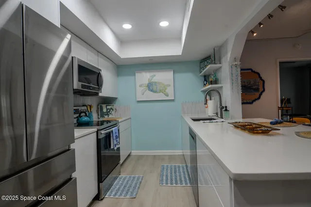 a kitchen with stainless steel appliances a sink stove and refrigerator