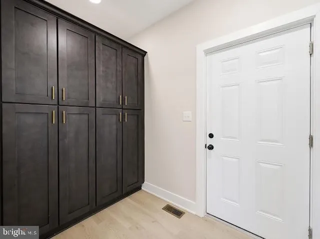 a view of a closet area with wooden floor