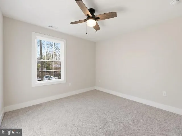 an empty room with a window and a fan