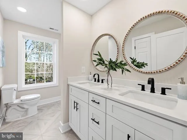 a bathroom with a granite countertop sink a toilet and a mirror