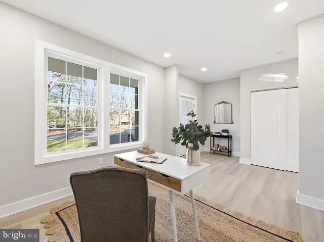 a living room with furniture and potted plants next to a large window